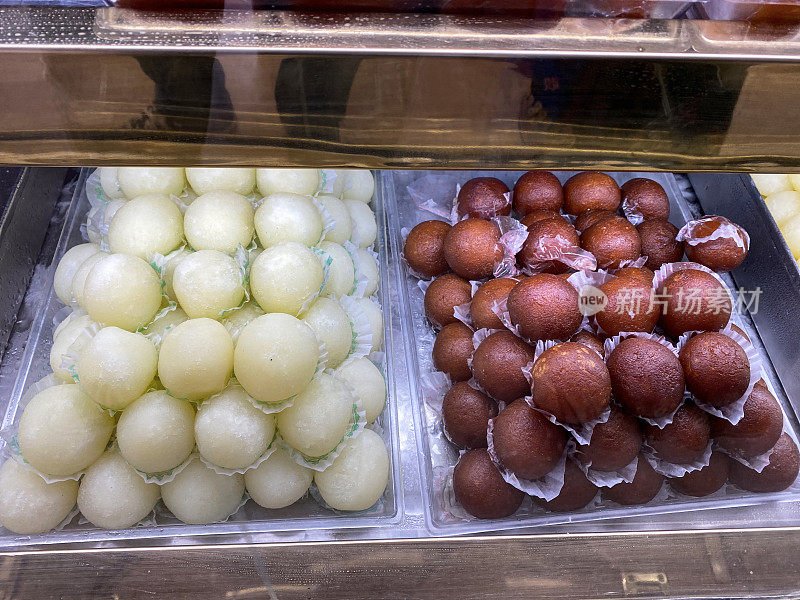 印度糖果店展示的rasgulla和Gulab jamun(玫瑰水莓)Mithai(糖果)的托盘图像，高架视图，关注前景